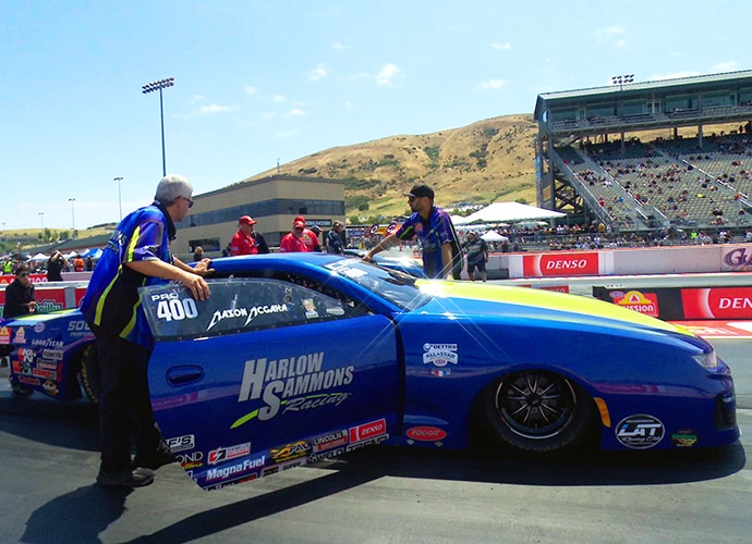 Blue racing car with a support crew.