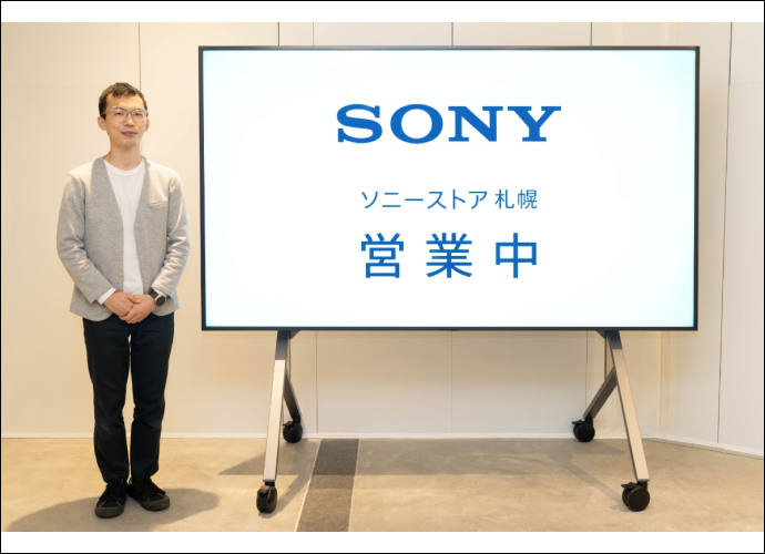 A Sony Store stylist next to a large BRAVIA screen with the Sony logo