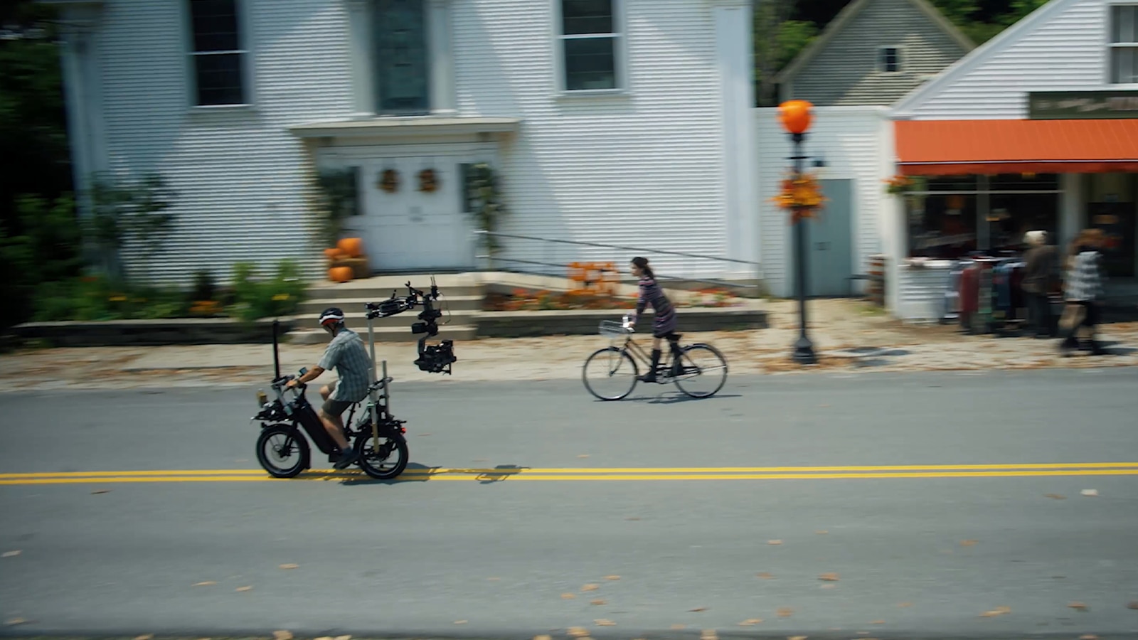 Wide shot of Jenna Ortega on bike being tracked by VENICE 2 camera on gimbal mounted on another bike