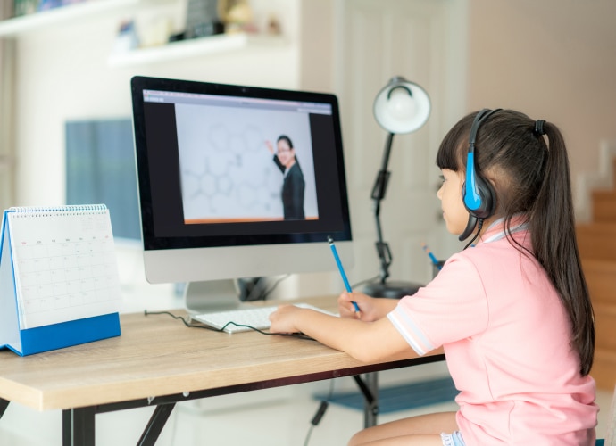 A young girl is watching a lesson on the PC