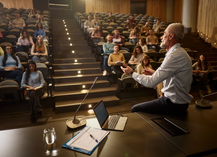 An image of the lecture hall with students and the lecturer