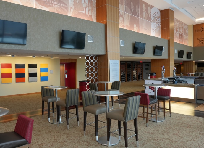 A bar area with a high ceiling, featuring multiple BRAVIA displays mounted on the upper walls