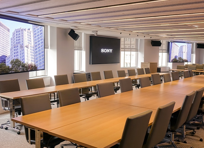 A large conference room with multiple video wall display showing the Sony Logo and building scenery